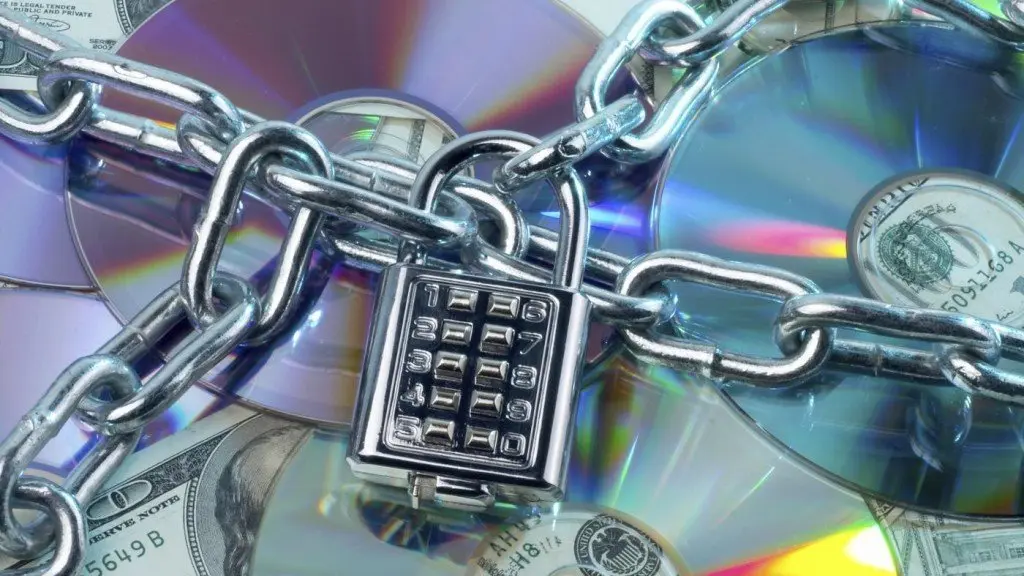 Россия и Беларусь: «защита авторских прав» или очередной шаг к поглощению? Цепи с кодовым замком, обвивающие компакт-диски и долларовые купюры, символизируют защиту авторских прав и ужесточение мер против нарушителей.